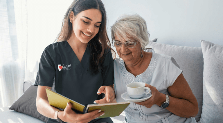Caregiver reading a book with a senior woman