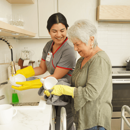 Caregiver helping a senior wash dishes