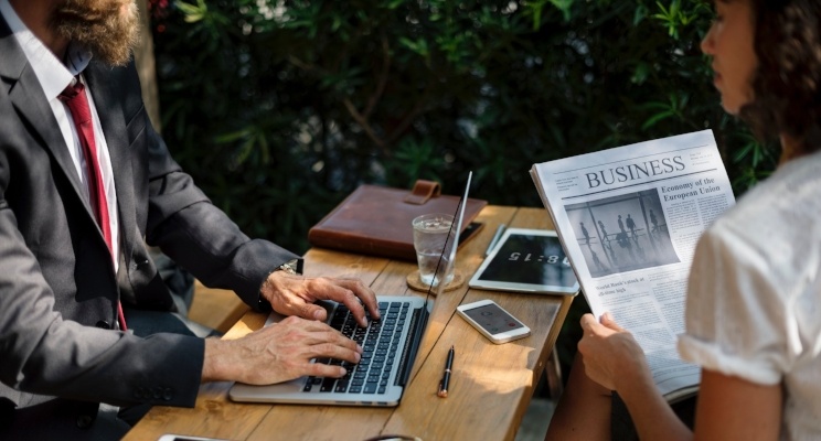Business people working outdoors at a wooden table