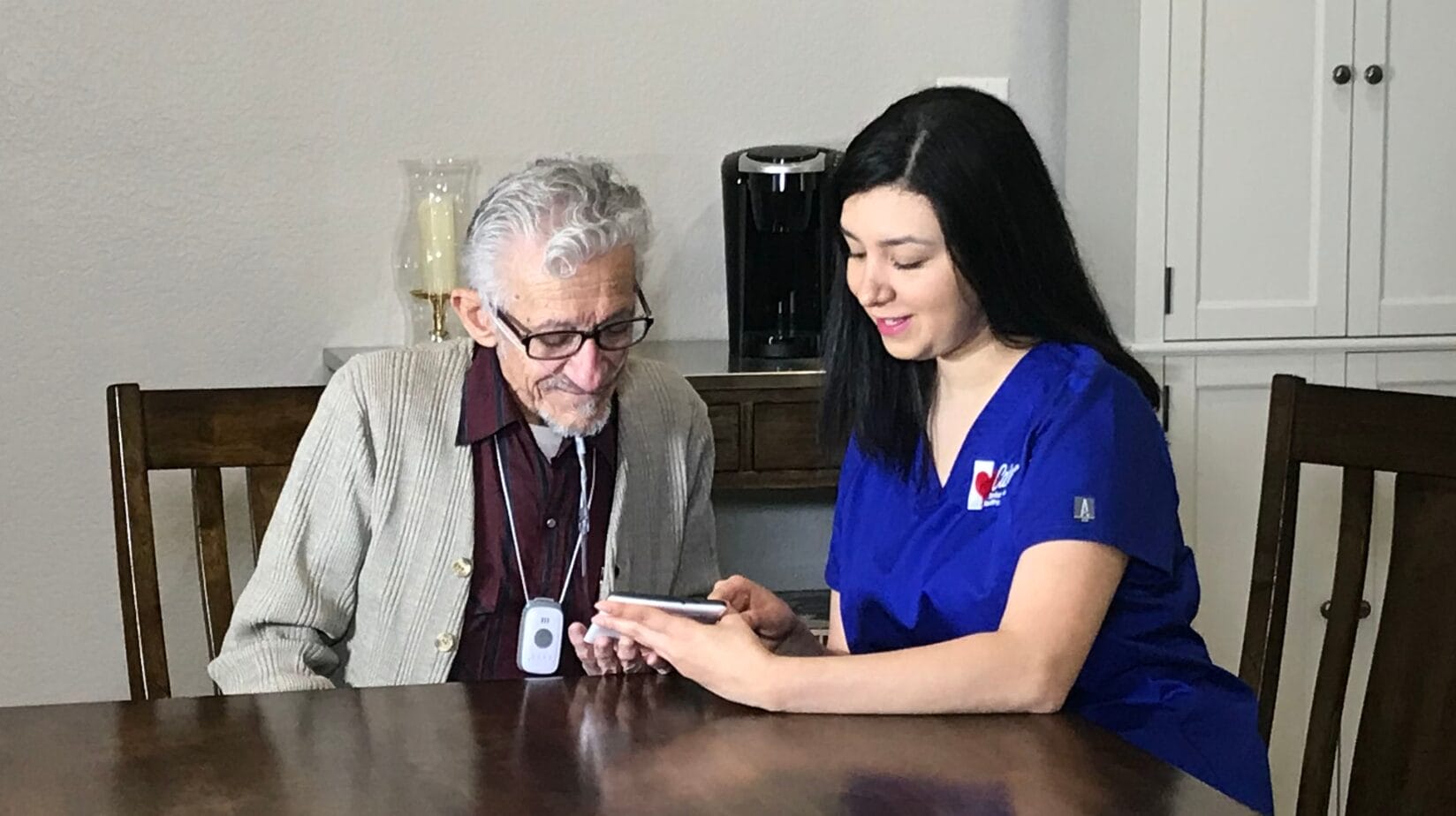 Caring Senior Service caregiver on a tablet with a client