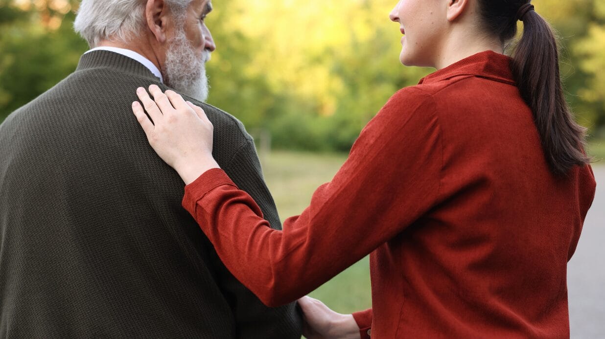 Caregiver walking with a senior man outside