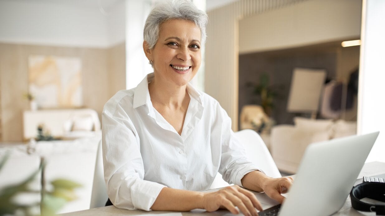 Confident female business owner working on a laptop