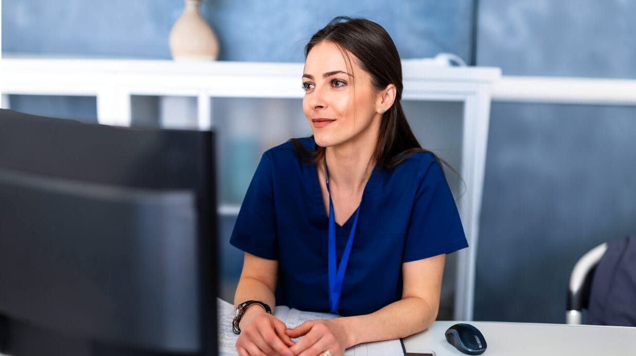 Healthcare administrator sitting at a computer