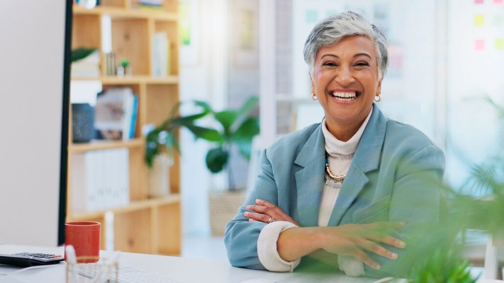 Confident older businesswoman smiling while in front of a computer