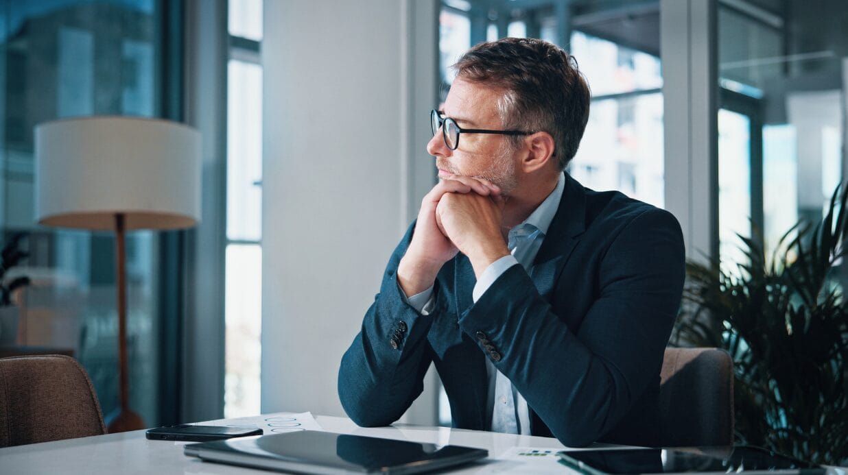 Male executive sitting pensively at his desk