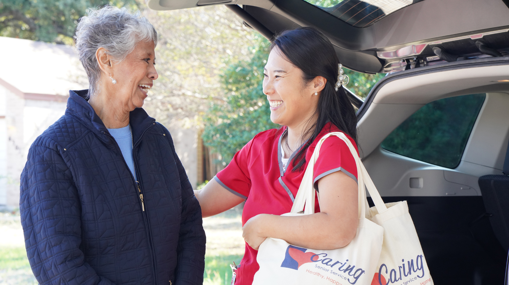 Caring Senior Service caregiver helping a senior get groceries out of the car