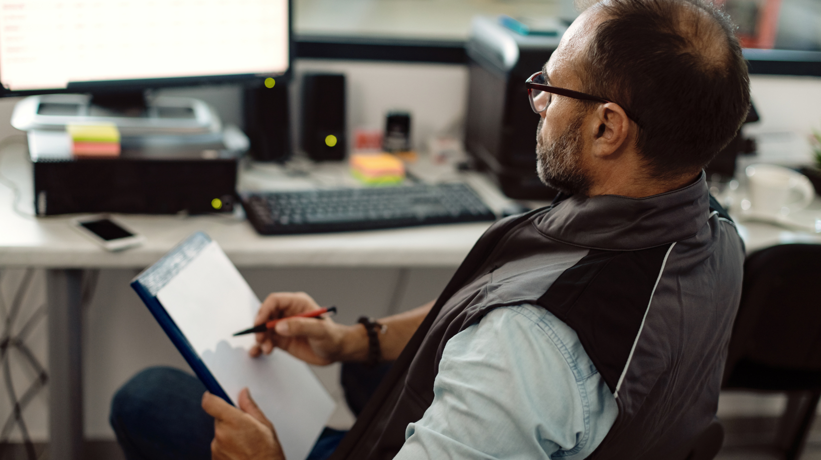 Business entrepreneur sitting at a desk reviewing paperwork